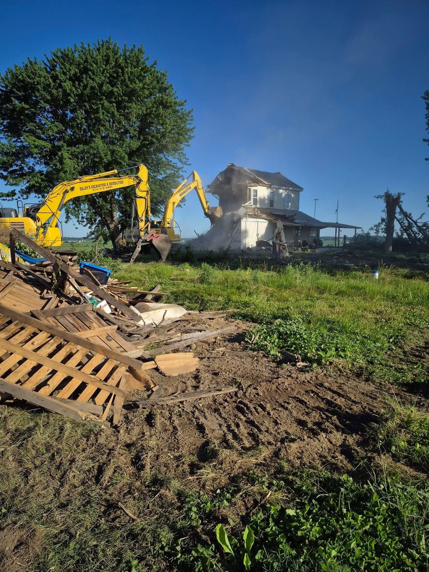 Two Dilley's excavators tearing down a two-story farmhouse